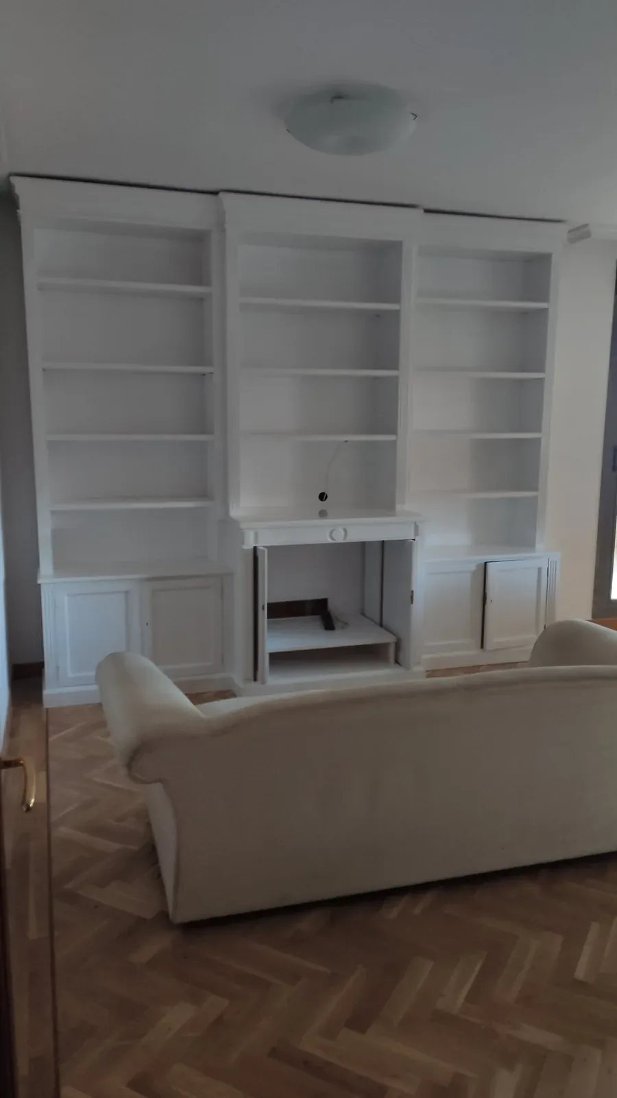 Librería con chimenea y módulos lacada en blanco en Colmenarejo