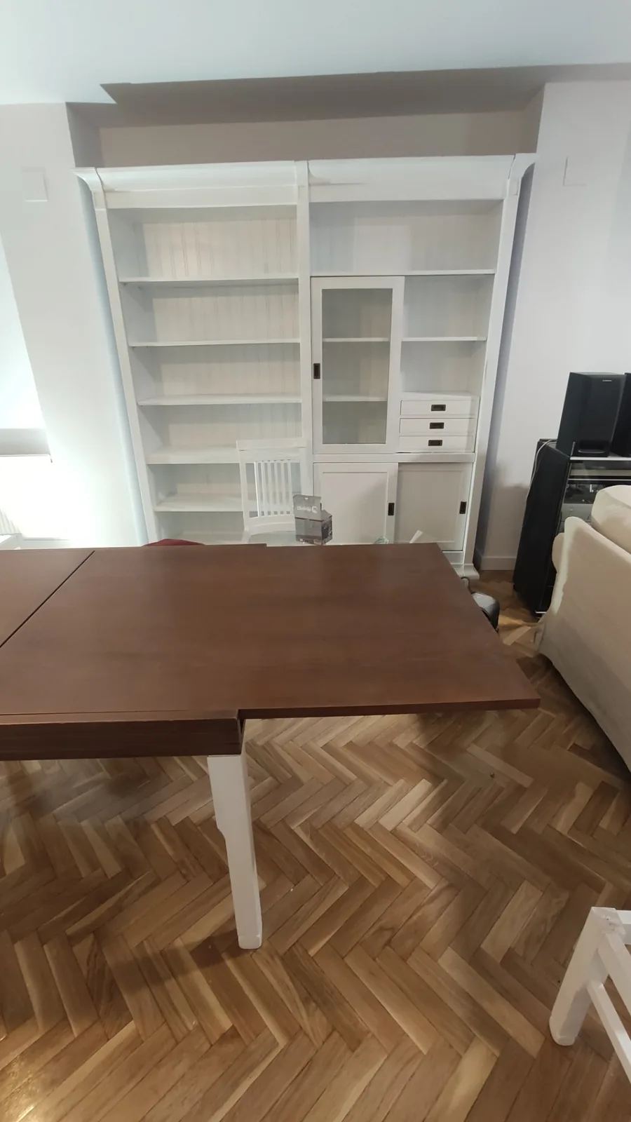 Librería de salón lacada en blanco con vitrina y cajones en Torrelodones